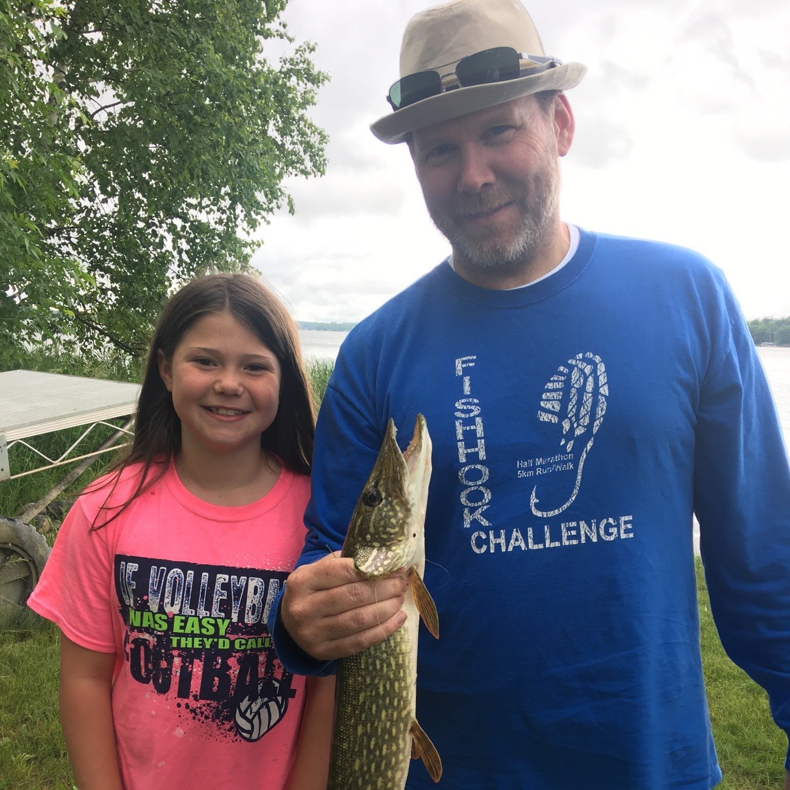 Dave Wilfahrt holding a northern pike by the lake